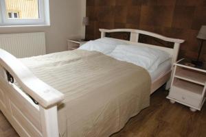 - une chambre avec un lit blanc et du parquet dans l'établissement Apartament Jedynka Villa Incognito, à Szklarska Poręba