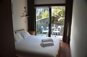 een slaapkamer met een bed en een balkon met een tafel bij PATH Dukes Apartment in Porto +34 foto's