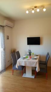 einen Esstisch mit Stühlen und einen TV in der Unterkunft Apartman Mery Stinjan in Pula