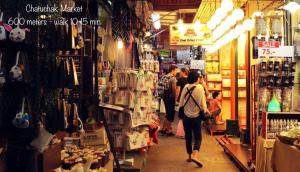 a group of people walking through a store at Yoo Yen Pen Sook in Bangkok