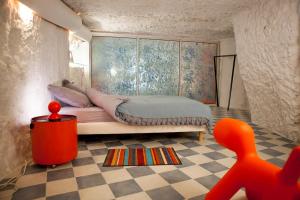 a bedroom with a bed and a red chair in it at Gîte de l'oppidum in Rochecorbon