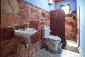 a stone bathroom with a sink and a toilet at Pousada Terras do Poente in Vale do Capao