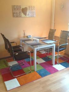 a dining room with a table and chairs on a colorful rug at Offenburg Apartment in Offenburg