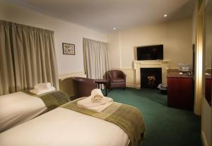 a hotel room with two beds and a fireplace at New Inn Hotel in Lechlade