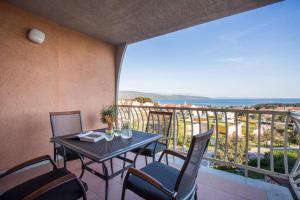 a balcony with a table and chairs and a view of the ocean at Apartment Zagrebačka in Krk