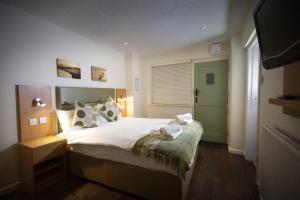 a bedroom with a bed and a green door at New Inn Hotel in Lechlade