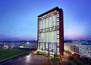 un palazzo alto con luci accese di notte di Atria Residences Gading Serpong a Serpong