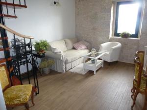 uma sala de estar com um sofá e uma cadeira em Kuća za odmor Viola em Živogošće