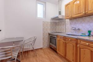 a kitchen with wooden cabinets and a table and chairs at SeaSide Guest Rooms in Burgas