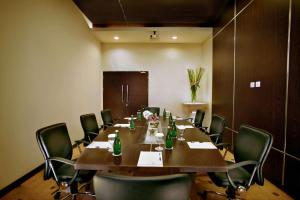 una sala conferenze con un lungo tavolo e sedie in legno di Atria Residences Gading Serpong a Serpong Altre 33 foto