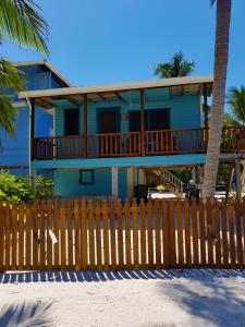 a blue house with a wooden fence in front of it at Carolyn's House in Caye Caulker