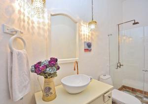 uma casa de banho com um lavatório e um vaso de flores num balcão em Hotel Casa Palosanto em Zapatoca