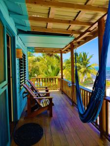 a porch with a hammock and a swing at Carolyn's House in Caye Caulker