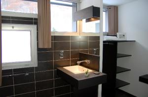 a bathroom with a sink and a window at Aux 500 Diables Eco Lodge - Hotel in Chambon-sur-Lac