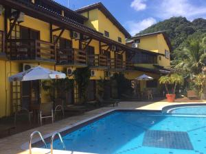 a hotel with a swimming pool in front of a building at Pousada Azul Banana - Maresias in Maresias