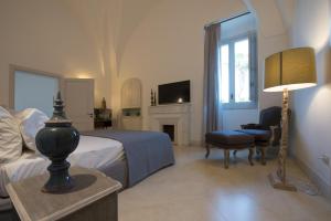 - une chambre avec un lit, une chaise et une cheminée dans l'établissement Villa Starace - Appartamento Romantico, à Sannicola