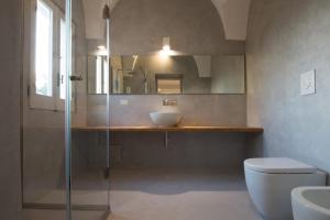 La salle de bains est pourvue d'un lavabo, de toilettes et d'un miroir. dans l'établissement Villa Starace - Appartamento Romantico, à Sannicola