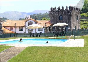 uma pessoa numa piscina em frente a um castelo em Casas da Loureira - Casa do Pote em Vila Nova de Cerveira