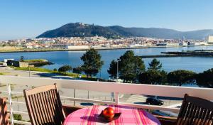 a table on a balcony with a view of the water at Pérola de Viana - Cabedelo in Viana do Castelo