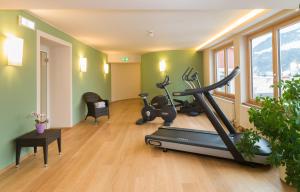 um ginásio com uma passadeira e bicicletas de exercício numa sala em Vergeiner's Hotel Traube em Lienz