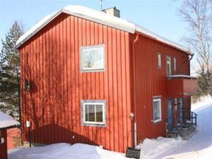 una casa roja con nieve a un lado. en Prästgården i Funäsdalen, en Funäsdalen