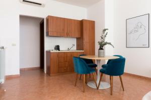 eine Küche mit einem Tisch und blauen Stühlen in der Unterkunft Sonder Piazza San Pietro in Rom