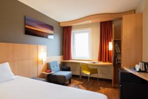 una camera d'albergo con un letto e una scrivania di ibis Rotterdam Vlaardingen a Vlaardingen