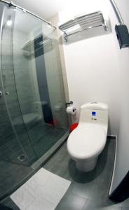 uma casa de banho com um WC e uma cabina de duche em vidro. em Hotel RDOS em Pasto