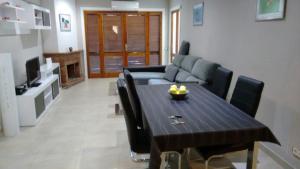 sala de estar con mesa y sofá en Entre Tres Playas Selectas, en Salou