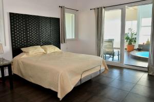 1 dormitorio con 1 cama grande y balcón en Sand Dollar Villa, en Boca Chica