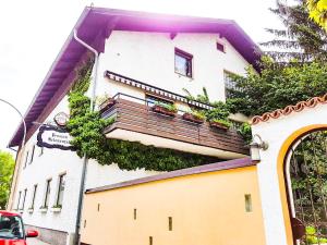 ein Gebäude mit einem Balkon mit Pflanzen in der Unterkunft Helenental Pension & Apartments in Baden