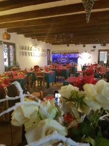 una sala da pranzo con tavoli, sedie e fiori di Al Fienile a Orzano