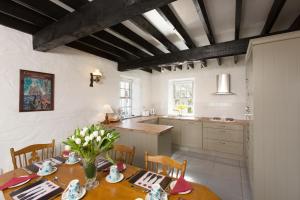 a kitchen and dining room with a table and chairs at Dunguaire Thatched Cottages in Galway