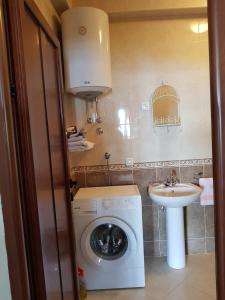 a small bathroom with a washing machine and a sink at Villa Look in Tivat