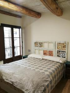 a bedroom with a large bed in a room with windows at Casa Blanquita in Molinaseca