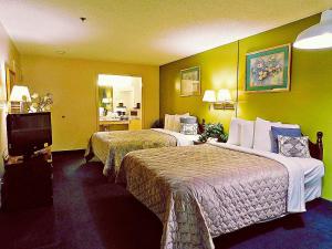a hotel room with two beds and a television at Americas Best Value Inn - Rome in Lindale