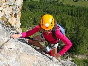 a girl in a yellow helmet climbing a mountain at Rock Noir & Spa in La Salle-les-Alpes