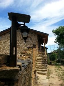 uma casa de pedra com uma luz ao lado dela em CASA RURAL Calma del Lago em Triufé