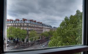 Elle offre une vue sur une rue de la ville depuis sa fenêtre. dans l'établissement Hotel Cluny Square, à Paris