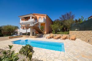 una villa con piscina di fronte a una casa di Apartments Jenny a Pinezići