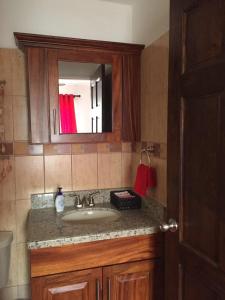 a bathroom with a sink and a mirror at Coco Beach Home in Coco