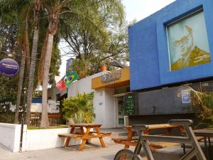 eine Gruppe Picknicktische vor einem Gebäude in der Unterkunft Hostel Hospedarte Chapultepec in Guadalajara