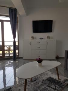 sala de estar con TV y tocador blanco en Frontal view by Twin Residence, en Mamaia