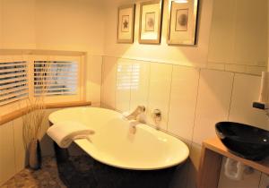 biała łazienka z umywalką i oknem w obiekcie Ulverstone River Edge HolidayApartments w mieście Ulverstone