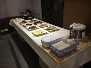 une table avec des assiettes de nourriture dans l'établissement Purple Garden Motel, à Kaohsiung