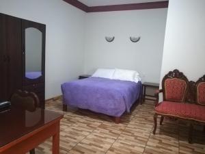 a bedroom with a bed and a mirror and a chair at Hostal El Remanso in Arequipa