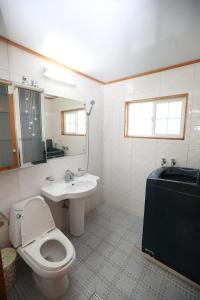 y baño con aseo blanco y lavamanos. en Gujeolcho Guesthouse en Gyeongju