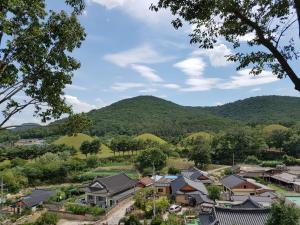 einen Überblick über ein Dorf mit Bergen im Hintergrund in der Unterkunft Gujeolcho Guesthouse in Gyeongju