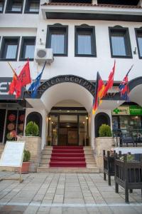 un bâtiment avec drapeaux devant un magasin dans l'établissement Hotel Beograd Struga, à Struga