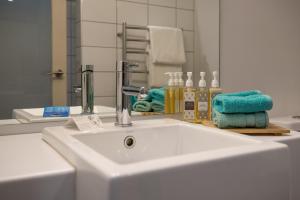 a white sink in a bathroom with a mirror at Navigate Seaside Hotel & Apartments in Napier